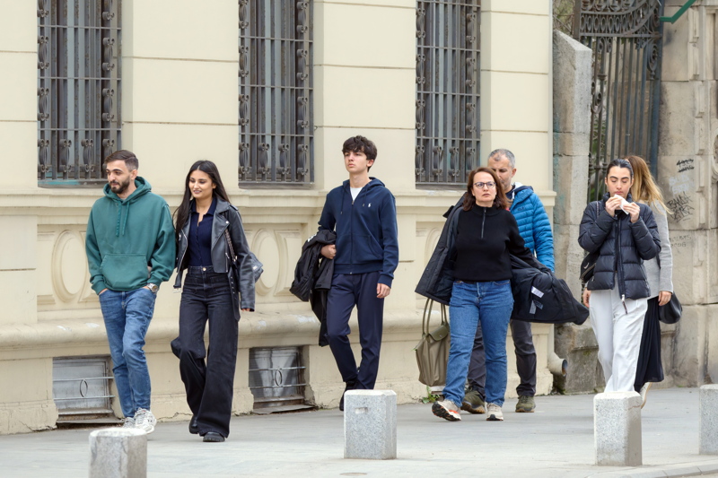 Young people walking on sidewalk